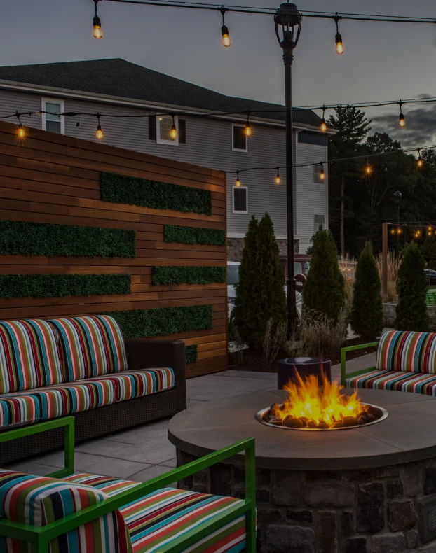Three friends laugh around a grill on a summer afternoon