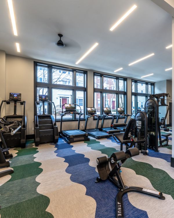 Three friends laugh around a grill on a summer afternoon