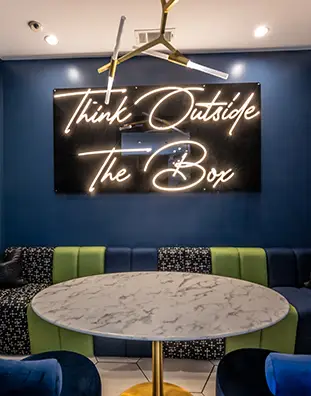Three friends laugh around a grill on a summer afternoon