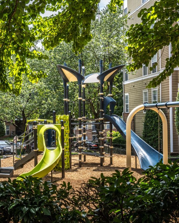 Three friends laugh around a grill on a summer afternoon