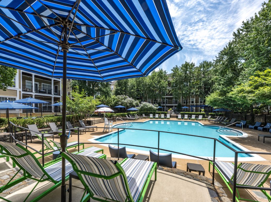 Three friends laugh around a grill on a summer afternoon