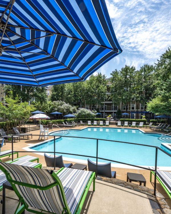 Three friends laugh around a grill on a summer afternoon