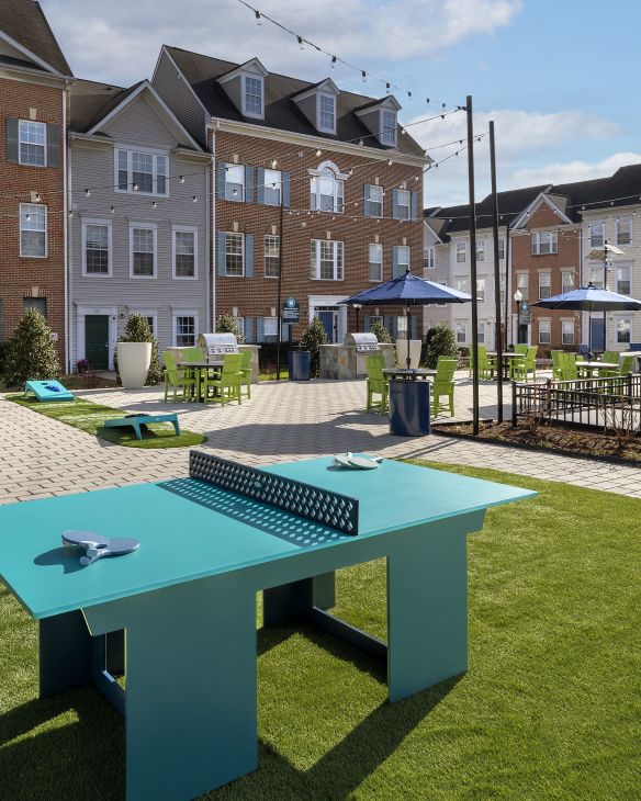 Three friends laugh around a grill on a summer afternoon