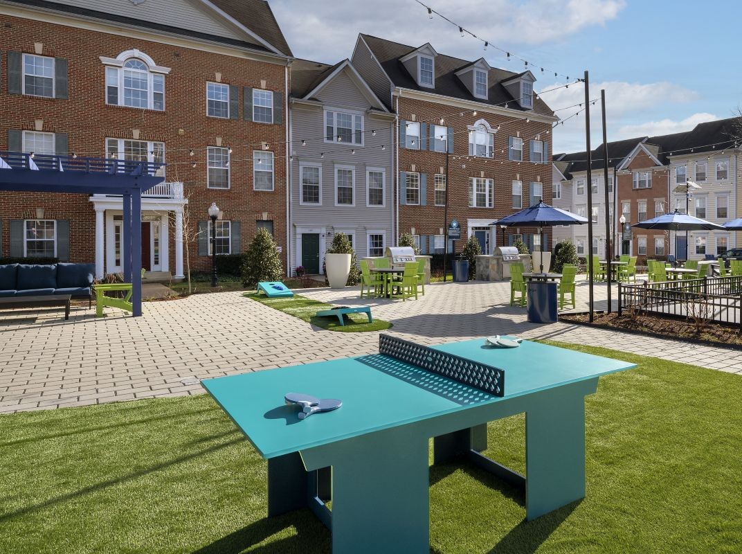Three friends laugh around a grill on a summer afternoon