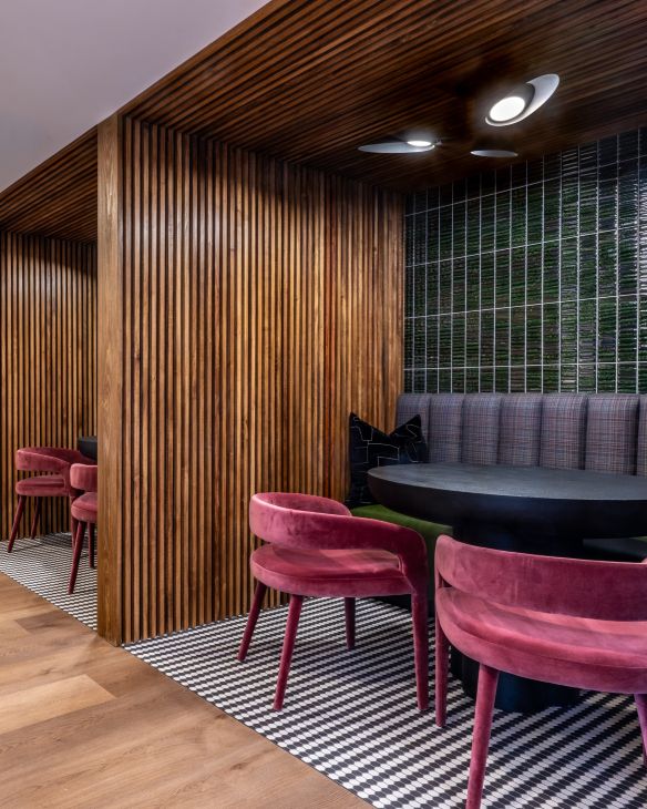 Three friends laugh around a grill on a summer afternoon