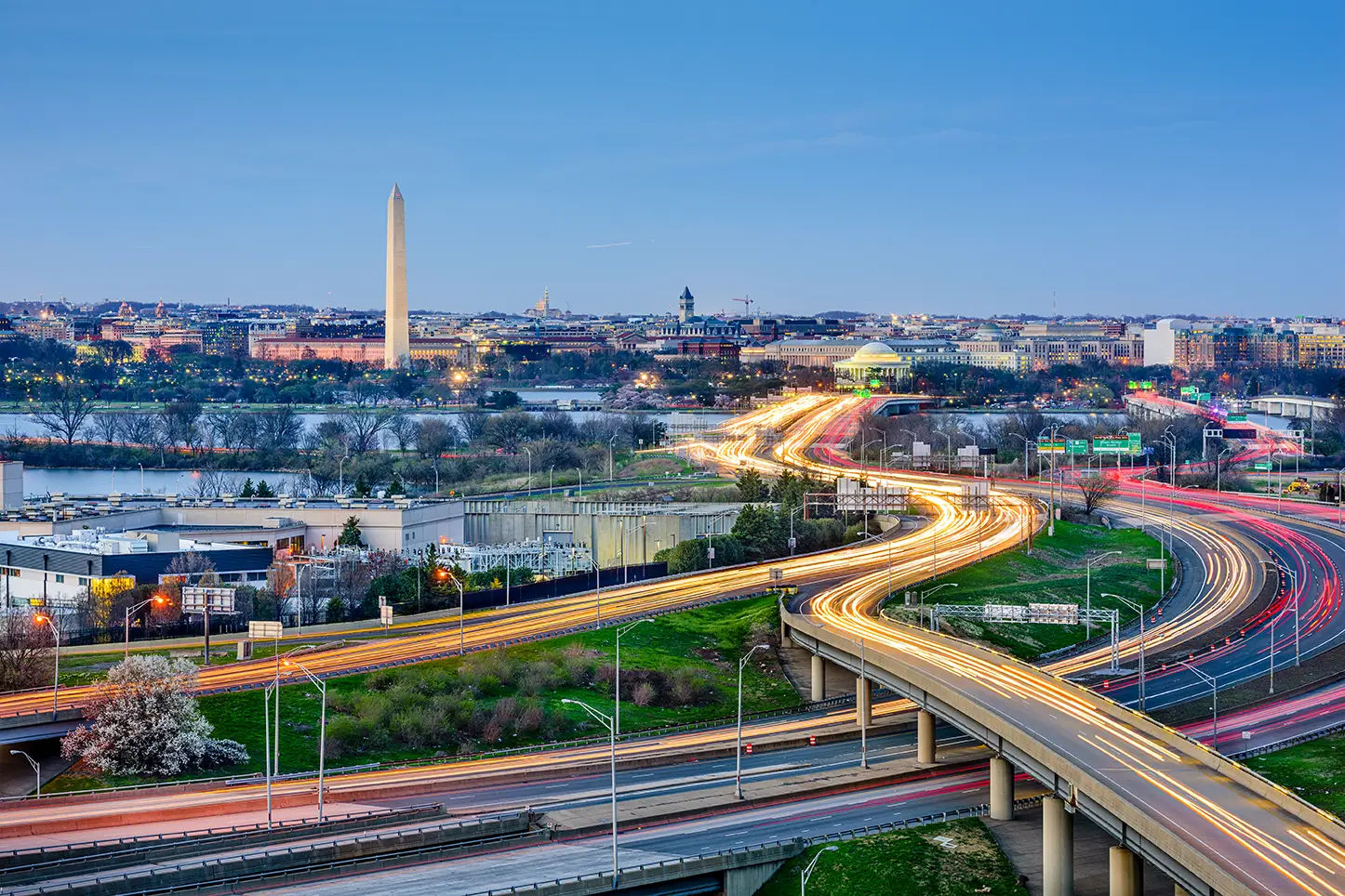 Washington DC skyline featuring Washington Monument with illuminated highways and light trail traffic views