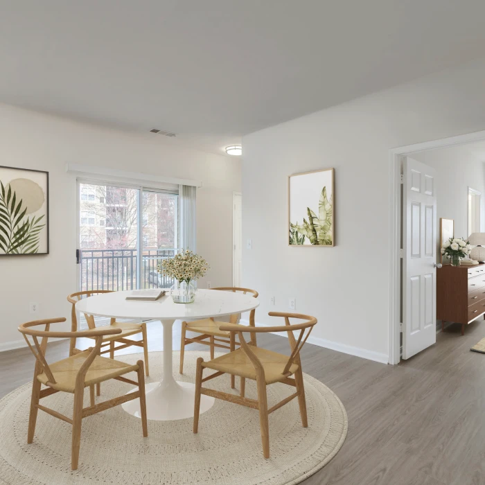Contemporary apartment dining area with round table, wooden chairs, and large sliding glass door access